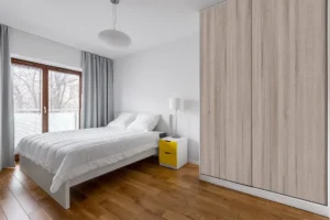 Wall cabinet constructed with New Mika 3260 Patinato Oak SUD High-Pressure Laminate, showcasing the material's clean, durable surface suitable for bedroom storage.