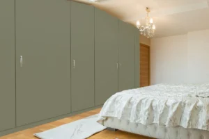 Modern wall cabinet made with New Mika 3561 Grey Out NOVEL GLOSS HPL laminate in a sleek wood-grain finish, featuring full-height storage and a contemporary bedroom interior design.